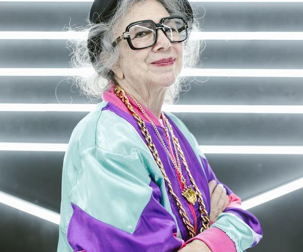A person smiling while doing a light exercise in their living room with a calendar in the background.