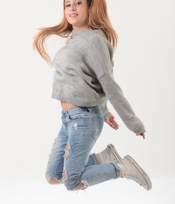 Energetic woman doing jumping jacks in a modern studio.